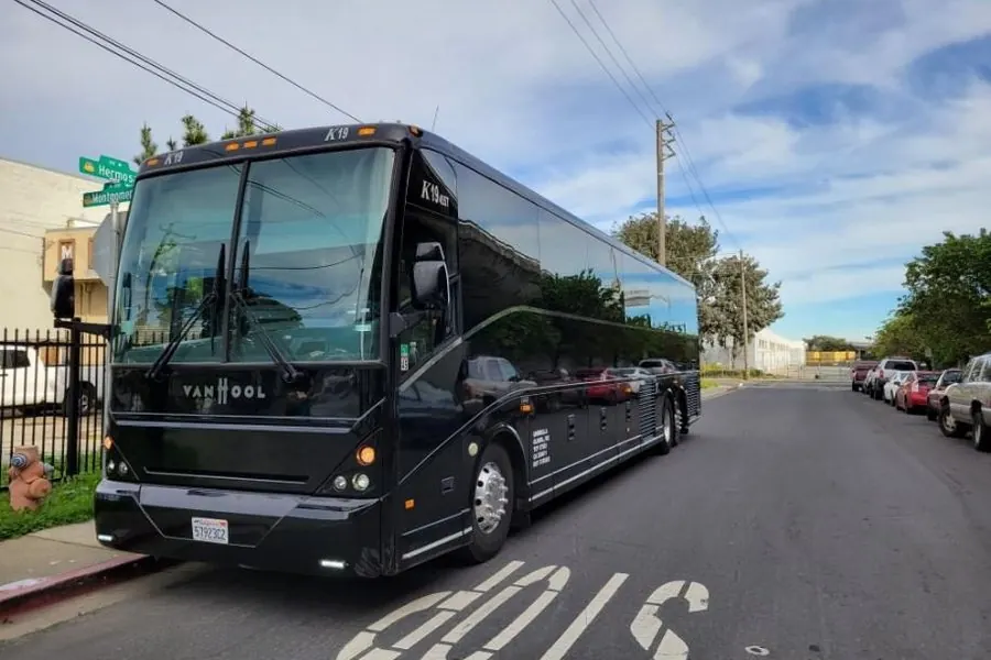 Black Van Hool CX45 56-passenger motorcoach owned by Umbrella Global Bus on a South San Francisco street